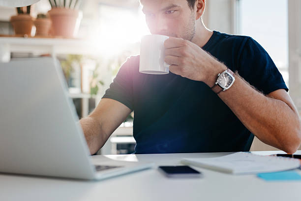 istock Young businessman with cup of coffee at work 612415314