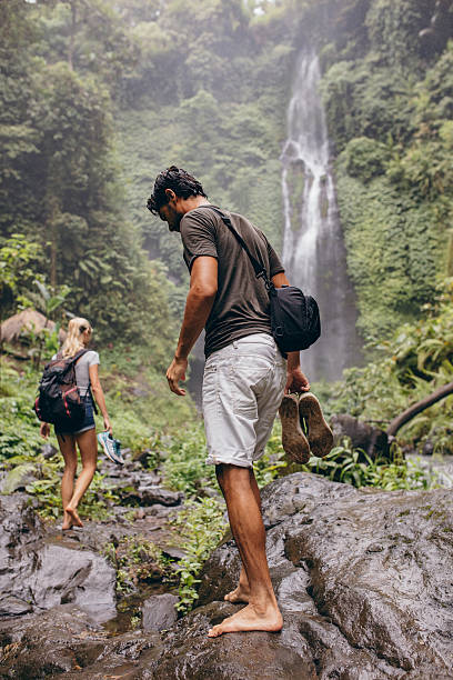 istock Young couple walking through mountain trail 612415604