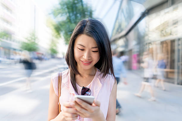 istock Asian woman texting on her phone 612415666