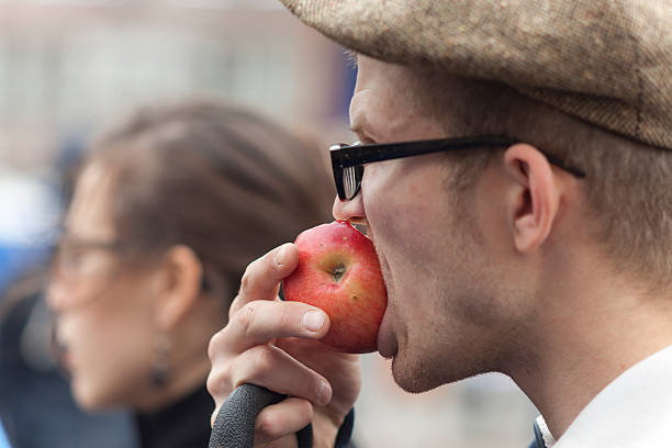 Moscow, Russia - September 15, 2012: Man eating the red apple and young woman in the crowd