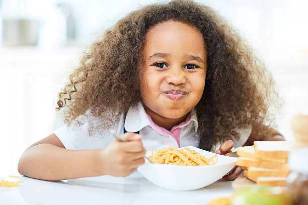 manger des pâtes - child eating pasta spaghetti photos et images de collection