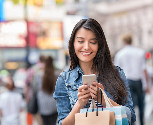 istock Woman text messaging while shopping 612420130