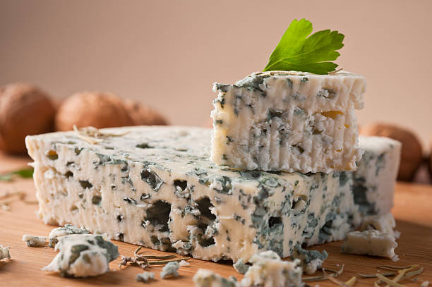 Slice of French Roquefort cheese Slice of French Roquefort cheese  with walnuts, copy space. roquefort cheese stock pictures, royalty-free photos & images