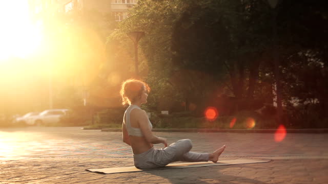 Young Woman Doing Yoga Meditation Exercises at Sunset