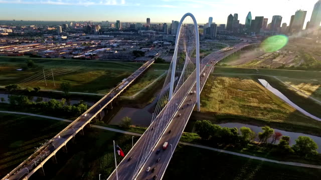 Margaret Hunt Hill Bridge spanning across the Trinity River in Dallas Texas During Sunirse circling around bridge