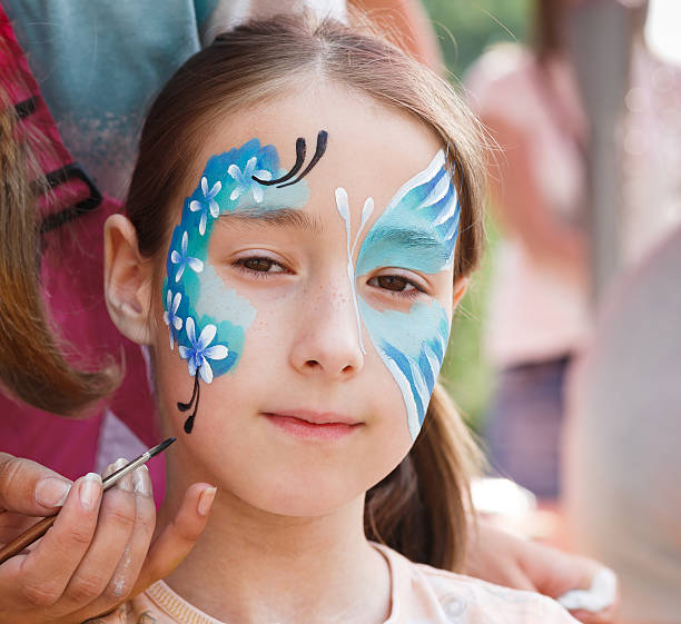 istock Female child face painting, making butterfly process 612479486