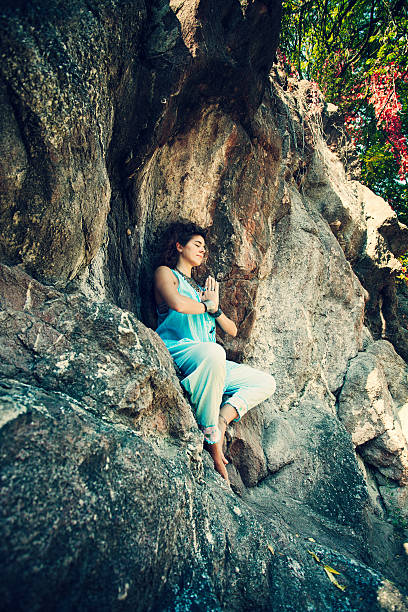 istock woman meditation on rock 612481974