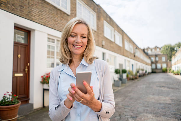 istock Happy woman using her mobile phone outdoors 612482558