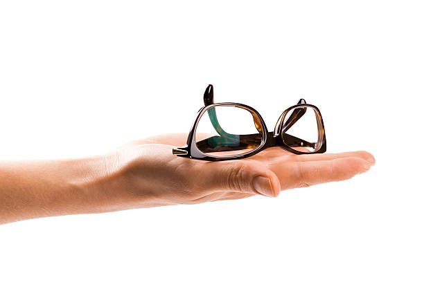 istock glasses on womans hand isolated on white background 612486690