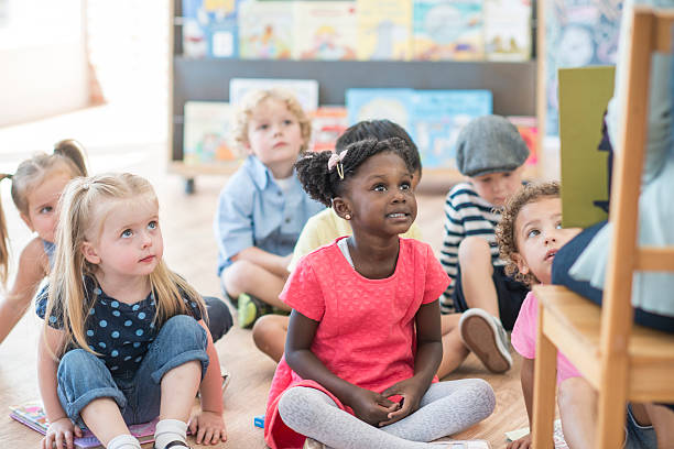 istock Listening to a Teacher Read a Book 612487216