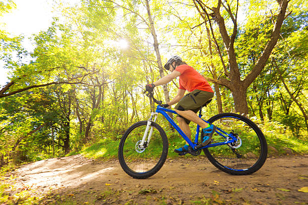istock Young Man Mountain Biking in Forest Trail 612487572