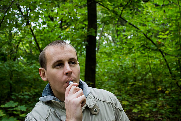 istock Man smoking electronic sigarette outdoor 612488694
