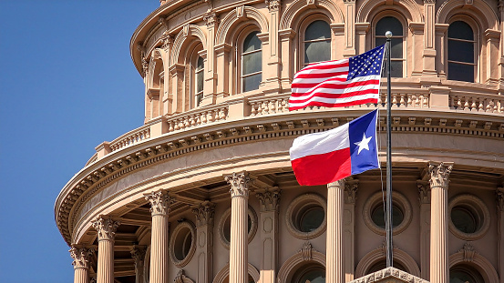 Bandera estadounidense y de Texas ondeando, Capitolio del Estado de Texas en Austin photo