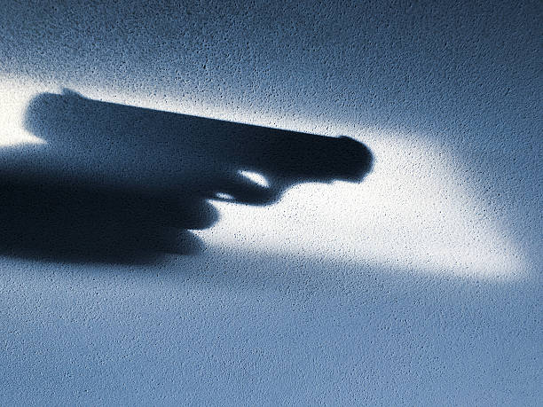 istock Shadow of a hand holding a gun 612491074