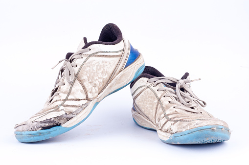 A pair of muddy sports shoes or trainers.