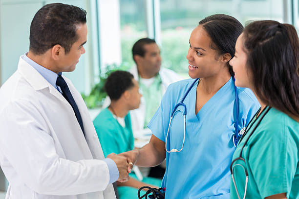 istock Hispanic doctor greets colleague before staff meeting 612495142