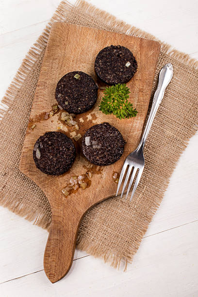 istock fried black pudding with onion and parsley on wooden board 612497492