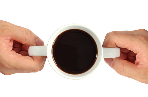 istock Two hands hold a cup of coffee in white background 612502398