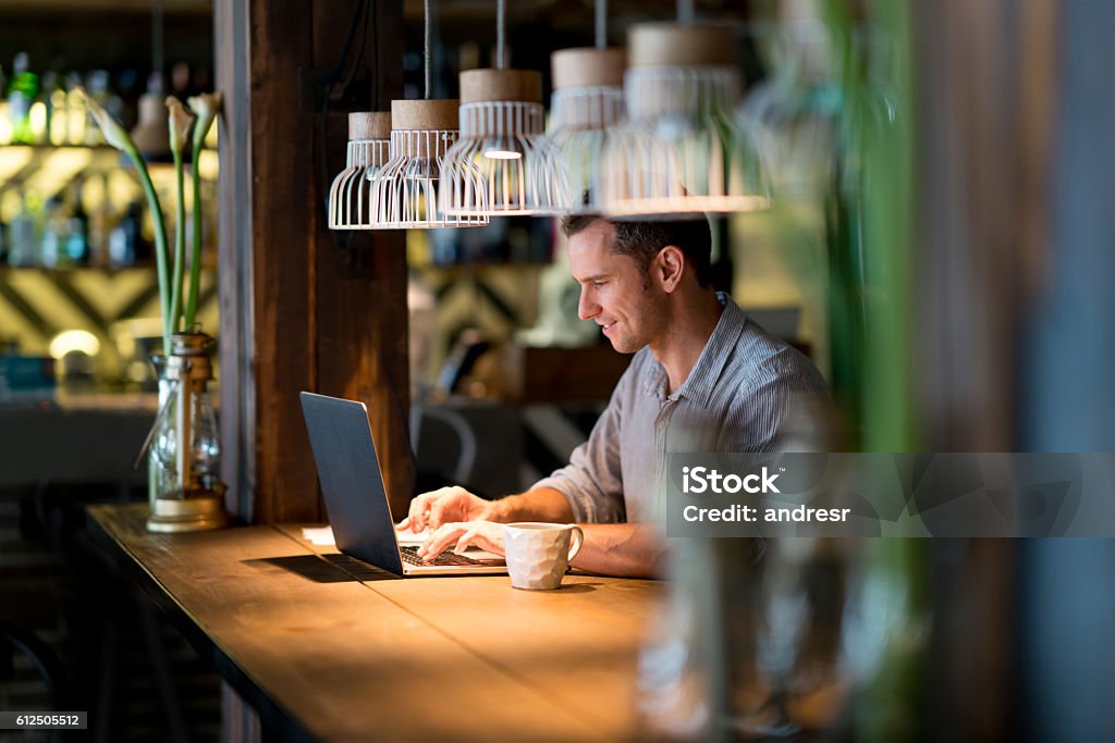 Business man working at a cafe Happy business man working at a cafe and using free wifi Cafe Stock Photo