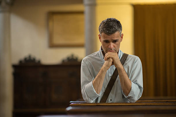 istock Man praying in the Church 612508578