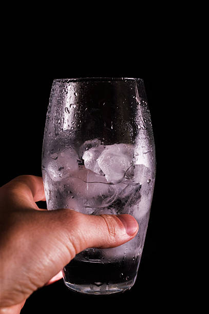 Hand holding glass with water and ice