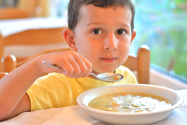 istock Boy Eating a Soup in Restaurant 612514088