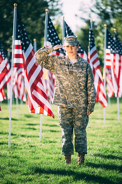 soldado americano saudando mulher em frente de bandeiras norte-americanas - armed forces latin american and hispanic ethnicity saluting marines - fotografias e filmes do acervo