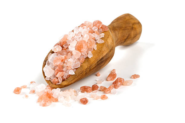 himalayan salt on a wooden spoon over white - pink salt imagens e fotografias de stock