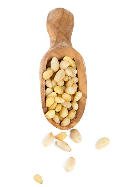 istock pine nuts in a wooden scoop isolated on white background 612515776