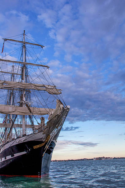 istock Old black wooden sailing ship under the sunset skies 612520788
