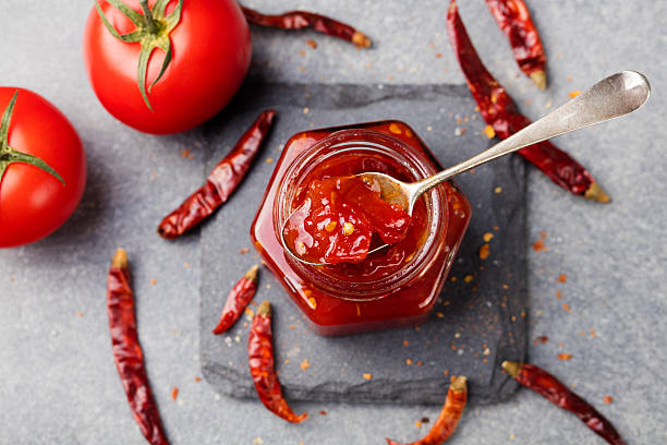 tomate y salsa picante, contratuerca, confiture en un vaso de cristal - chutney jar tomato preserved fotografías e imágenes de stock