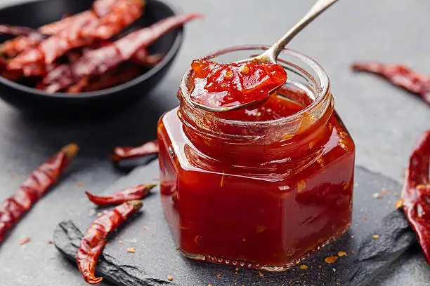 Photo of Tomato and chili sauce, jam, confiture in a glass jar