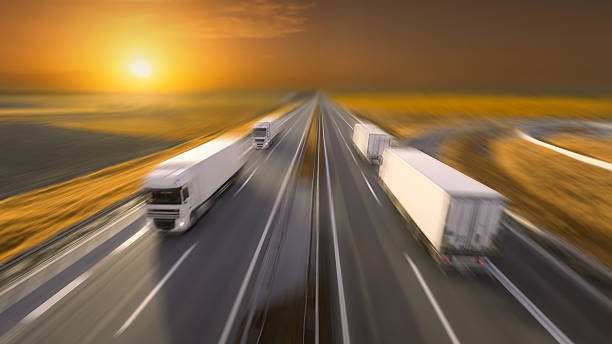 istock Trucks in motion blur on the empty highway at sunset 612521996