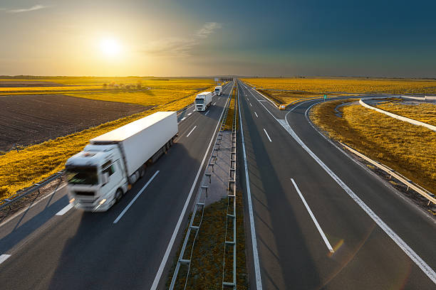 istock Three trucks on the freeway at idyllic sunset 612522490