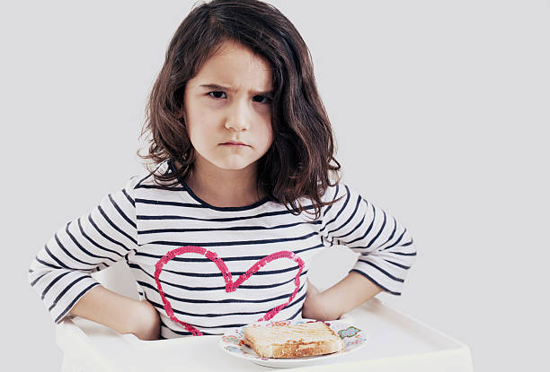 istock Frowning little girl at breakfast 612522548