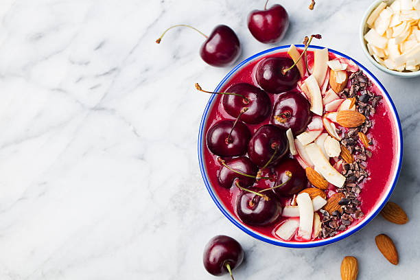 smoothie bowl with fresh black cherries, coconut flakes, almond. - yoghurt chocolate bowl bildbanksfoton och bilder