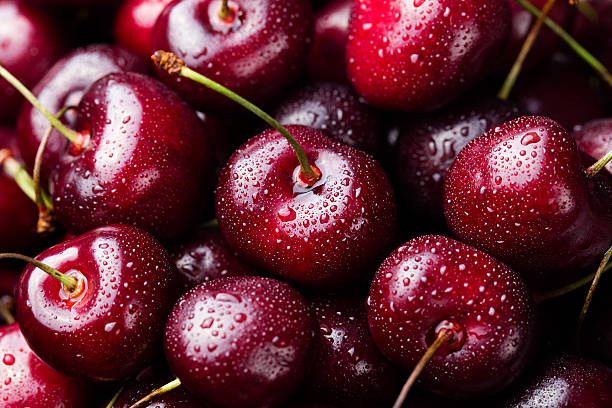 fresh ripe black cherries background top view close up - fruit fotos stockfoto's en -beelden