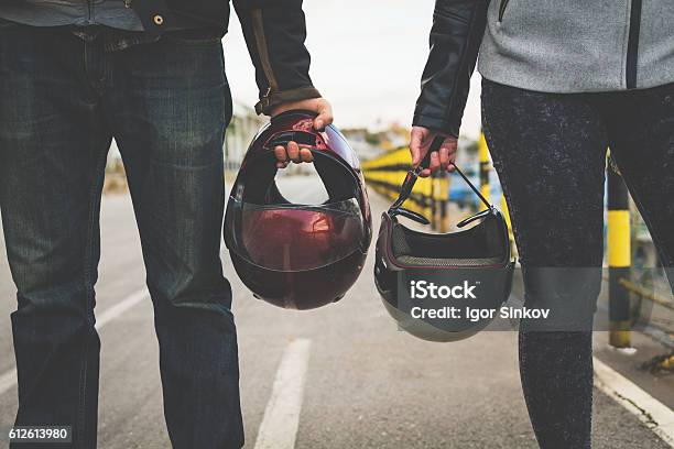 Motorcycle Couple Holding Helmets In Hands Stock Photo - Download Image Now - Motorcycle, Couple - Relationship, Two People