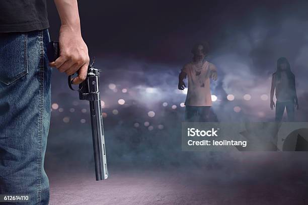 Brave Man With Jeans Pants Holding Gun Looking At Zombies Stock Photo - Download Image Now