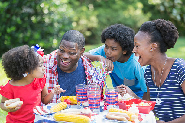 afroamericana de raza mixta familia al picnic el 4 de julio - us memorial day flag hot dog usa fotografías e imágenes de stock