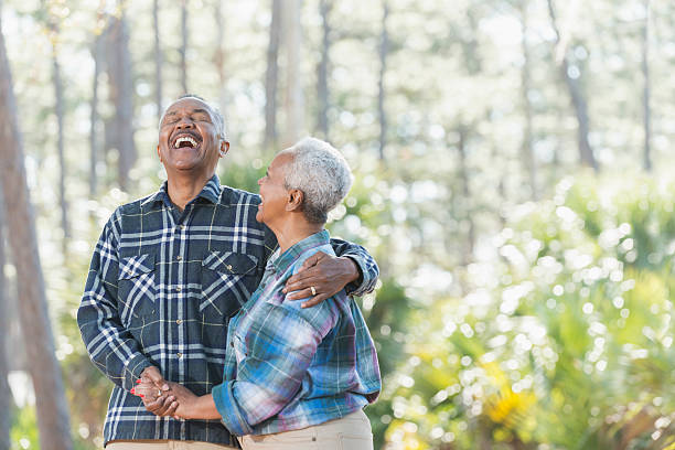 pareja afroamericana de la tercera edad cogía de la mano en el parque - autumn women park forest fotografías e imágenes de stock