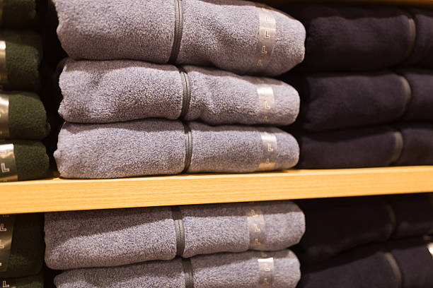 fleece pullover stapel im regal im einzelhandel - fleece coat stock-fotos und bilder