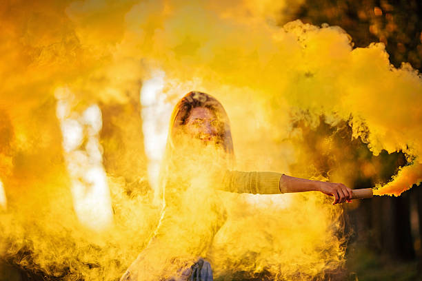 istock Girl covered in yellow smoke 612619406