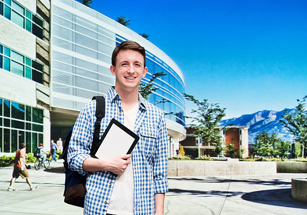 Smiling student standing at the campus Smiling student standing at the campus brigham young university stock pictures, royalty-free photos & images