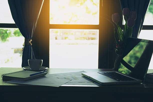 istock Laptop, notebook, coffee cup with financial documents on wooden table 612621482