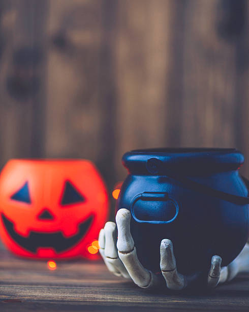 istock Halloween still life. Skeletal hand holding empty cauldron 612623814