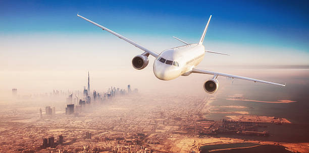 istock Commercial airplane flying over modern city 612624026
