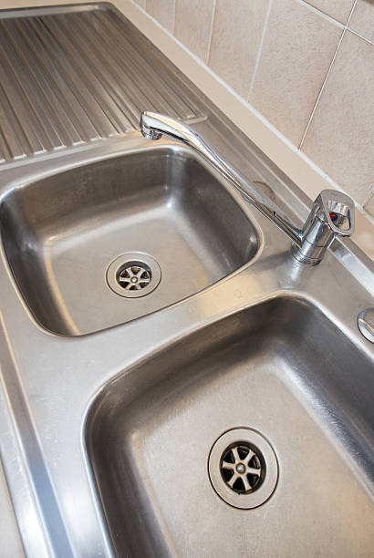 istock Mixer tap Faucet on a twin kitchen sink 612624990