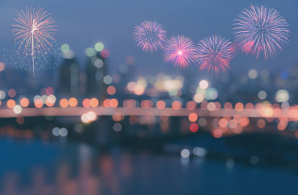 Colorful fireworks on twilight sky background with blurred city lights bokeh illuminate at night