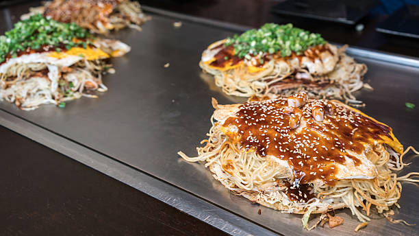 estilo hiroshima okonomiyaki ou pizza japonesa - adulation asia cooked food - fotografias e filmes do acervo